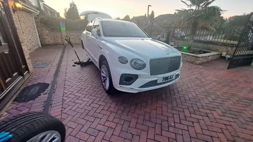 A Bentley car getting new tyres fitted by a Lucky Mobile Tyres mechanic